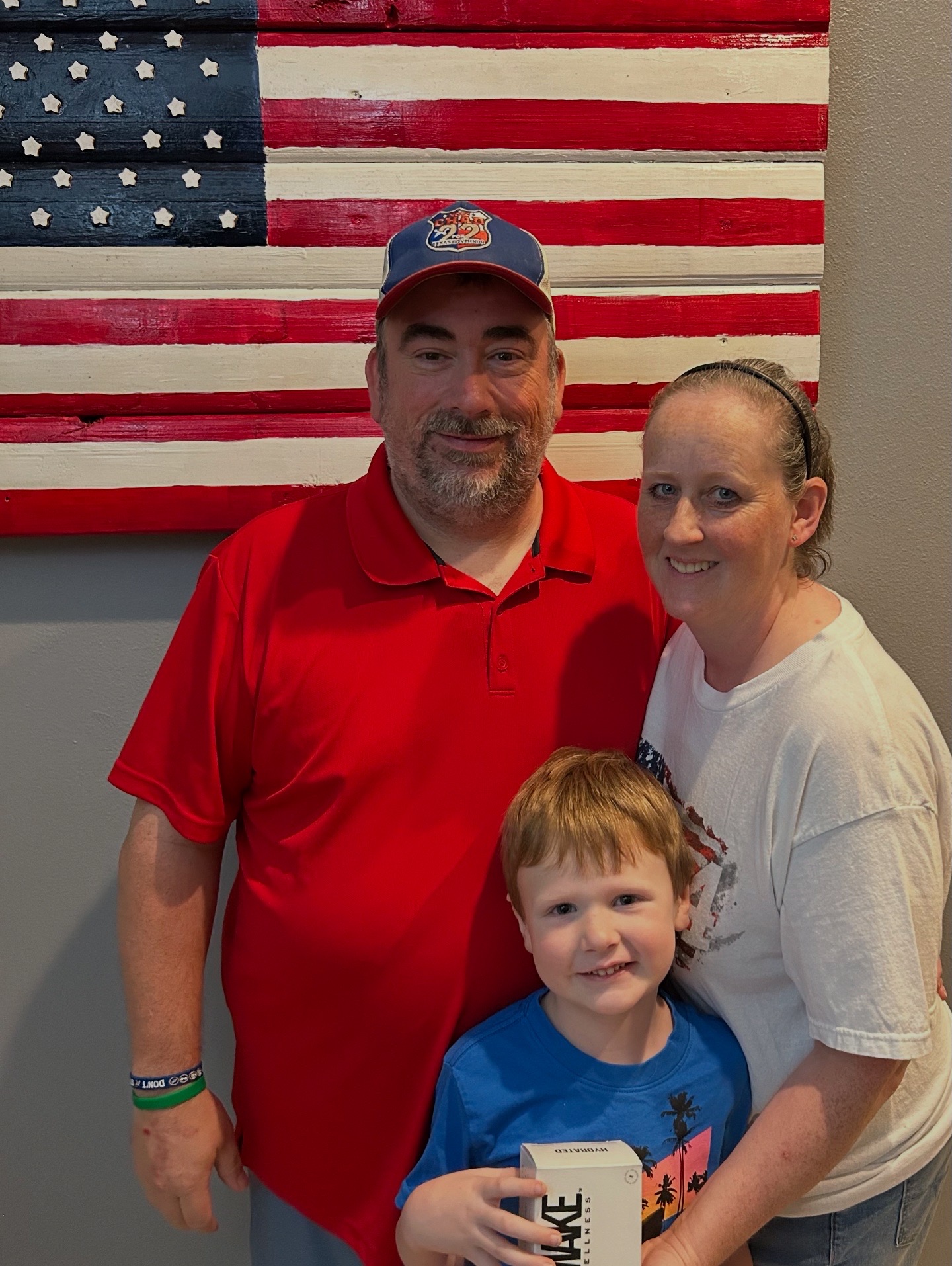 Wade, Laura and Wyatt together in front of an American flag